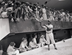06 Mar 1948, Santo Domingo, Dominican Republic --- Original caption: On his first day of spring training with the Brooklyn Dodgers here, Jackie Robinson, Negro first baseman, proved a prime favorite with San Dominicans. He is shown here giving his autograph to some of the natives who watched the Dodgers workout at the Trujillo High School grounds. --- Image by © Bettmann/CORBIS